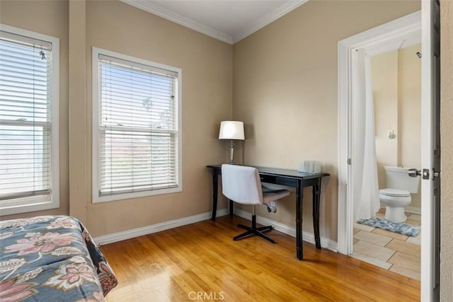 bedroom featuring baseboards, ensuite bath, ornamental molding, and light wood finished floors