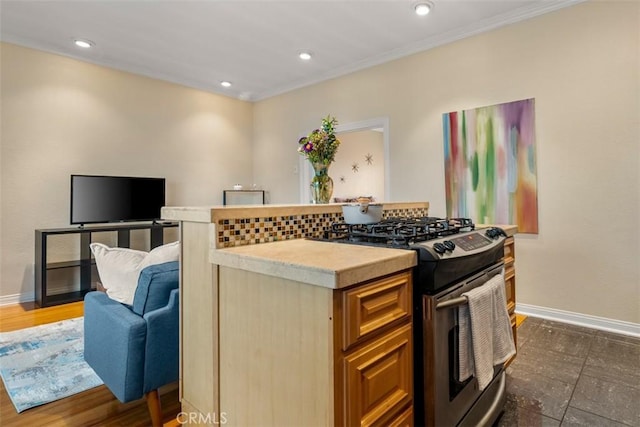 kitchen with stainless steel range with gas stovetop, light countertops, baseboards, and open floor plan