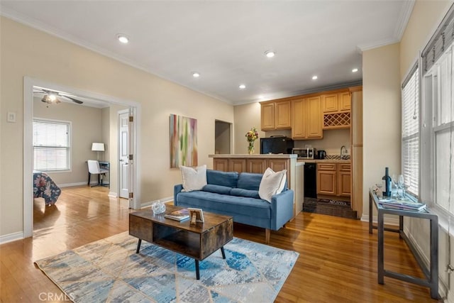 living area featuring light wood finished floors, baseboards, recessed lighting, and ornamental molding