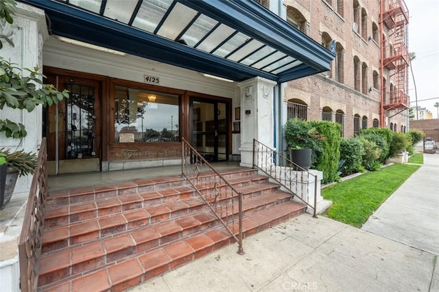view of exterior entry with brick siding