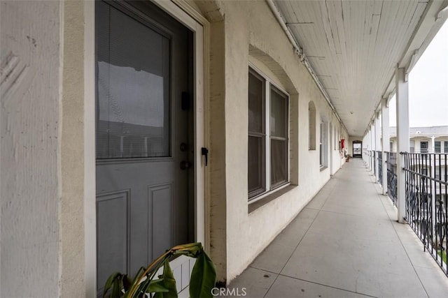 doorway to property with a balcony and stucco siding