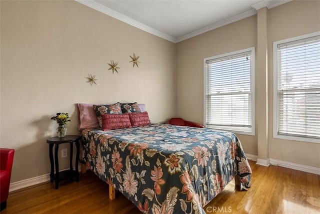 bedroom featuring baseboards, ornamental molding, and wood finished floors