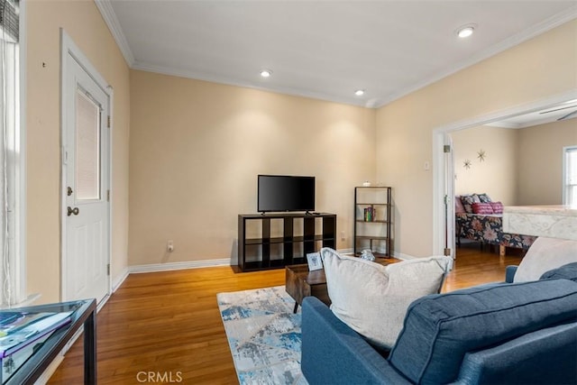 living room featuring baseboards, wood finished floors, recessed lighting, and crown molding