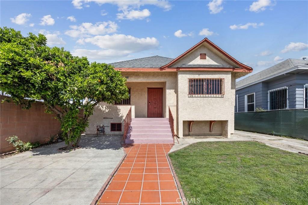 339 E 35th St, Los Angeles, CA 90011 - view of front of home with a front yard, stucco siding, and fence