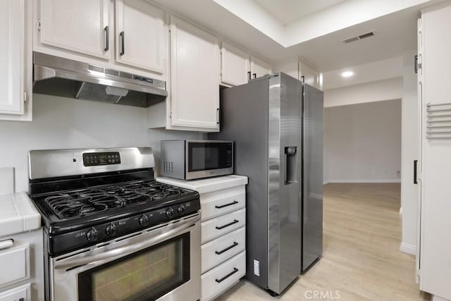2903 Yucatan Pl Unit A, Diamond Bar, CA 91765 - kitchen with visible vents, appliances with stainless steel finishes, under cabinet range hood, tile counters, and white cabinetry