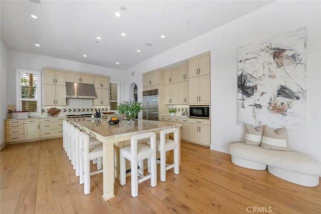 31 Seawatch, Newport Coast, CA 92657 - kitchen with built in appliances, cream cabinetry, under cabinet range hood, light wood-style floors, and recessed lighting