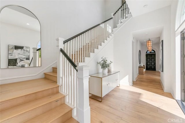 31 Seawatch, Newport Coast, CA 92657 - stairs with wood-type flooring, a high ceiling, arched walkways, and baseboards