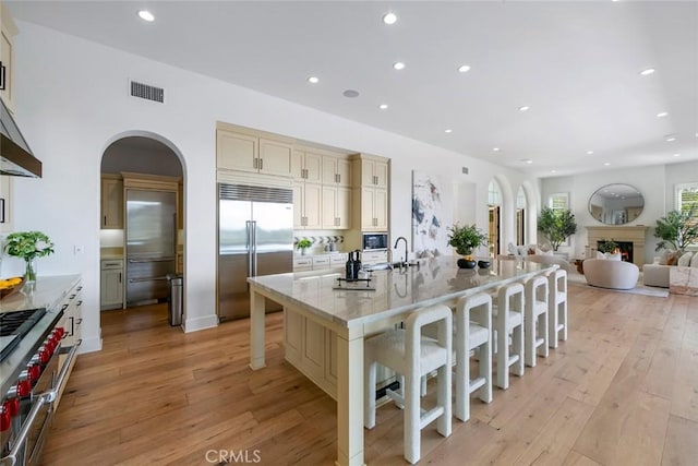 31 Seawatch, Newport Coast, CA 92657 - kitchen with built in appliances, a kitchen bar, light wood finished floors, recessed lighting, and cream cabinets