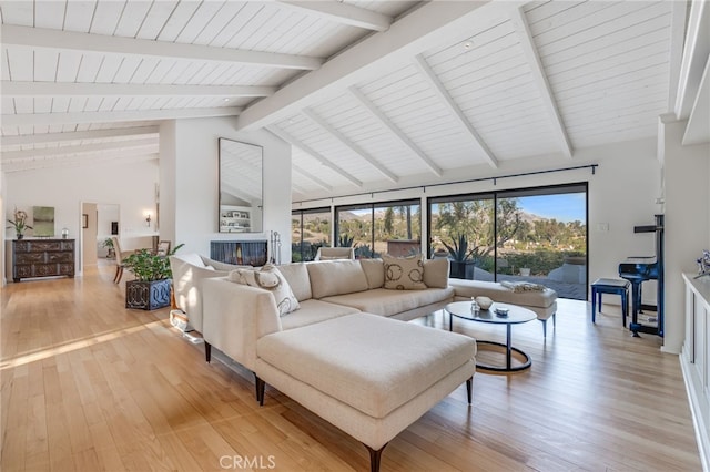 living area with light wood finished floors, beam ceiling, and wood ceiling
