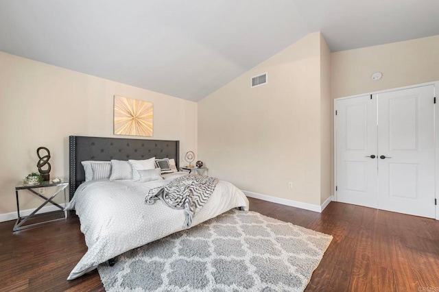 bedroom with visible vents, baseboards, wood finished floors, and vaulted ceiling