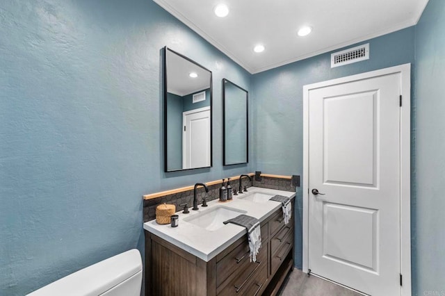 bathroom with a sink, a textured wall, toilet, and visible vents