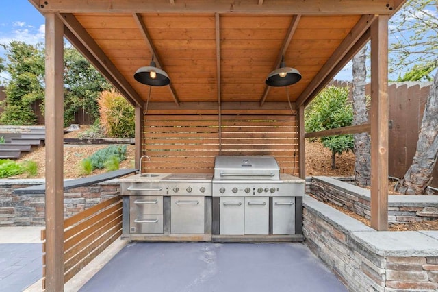 view of patio with fence, a sink, and area for grilling