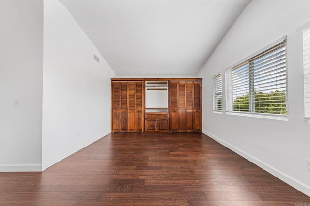 interior space featuring visible vents, lofted ceiling, and dark wood-style floors