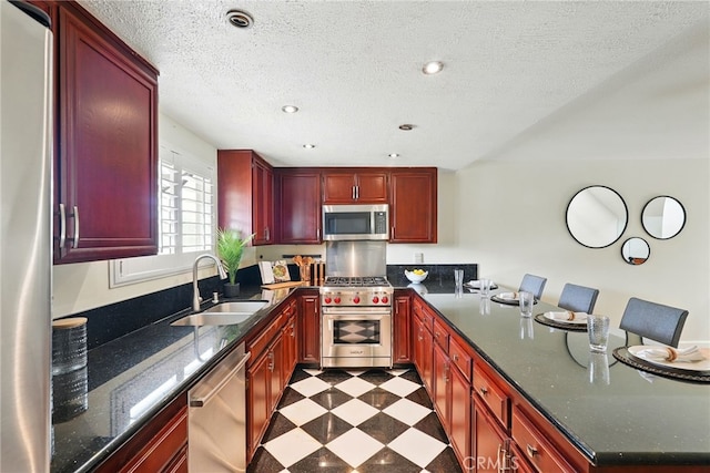 5447 E Centralia St, Long Beach, CA 90808 - kitchen with appliances with stainless steel finishes, a sink, dark brown cabinets, a peninsula, and dark flooring