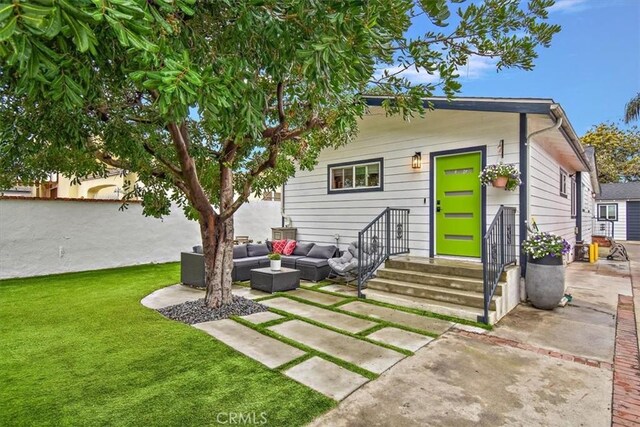 rear view of property with an outdoor living space, fence, a yard, and a patio