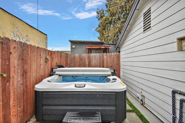 exterior space featuring fence and a hot tub