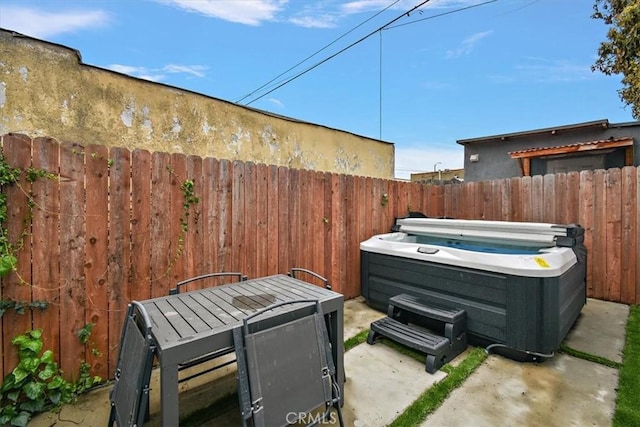 view of patio featuring a fenced backyard and a hot tub