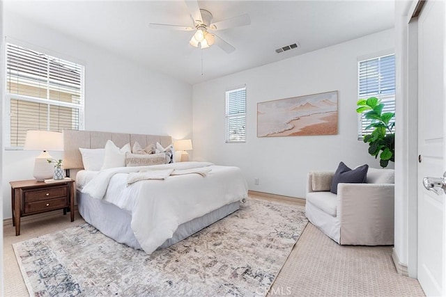bedroom with baseboards, a ceiling fan, visible vents, and multiple windows