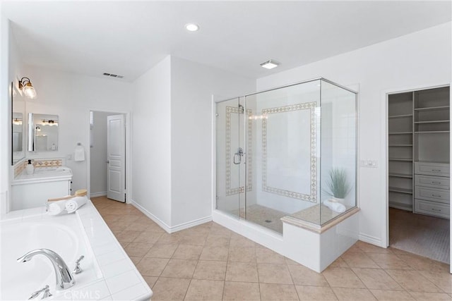 full bath featuring tile patterned floors, visible vents, baseboards, a garden tub, and a stall shower