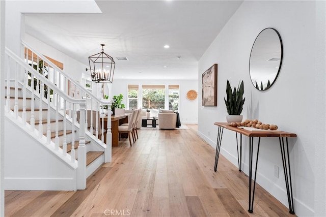 entryway with recessed lighting, stairway, light wood-style flooring, and an inviting chandelier