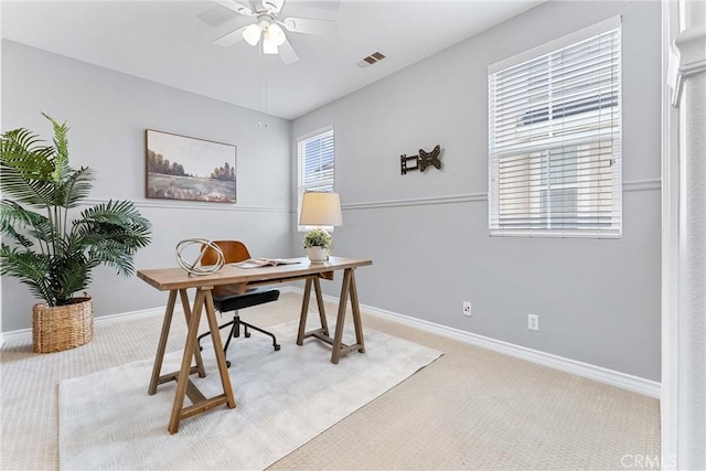 carpeted home office with visible vents, a ceiling fan, and baseboards