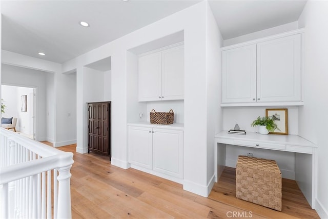 hallway with recessed lighting, light wood finished floors, and baseboards