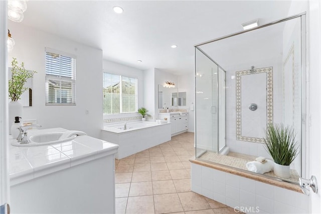 bathroom featuring visible vents, a sink, a bath, two vanities, and a stall shower