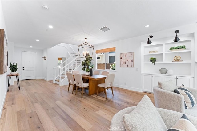 dining space with stairway, a chandelier, light wood-type flooring, baseboards, and visible vents