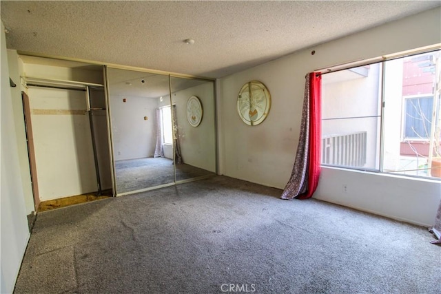 unfurnished bedroom with a closet, carpet, and a textured ceiling