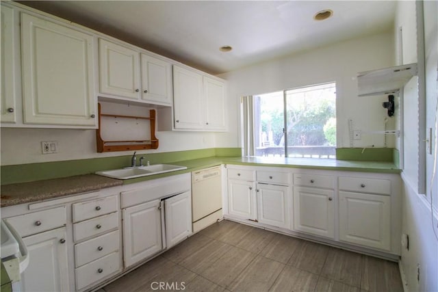 kitchen featuring light countertops, white cabinets, a sink, and white dishwasher
