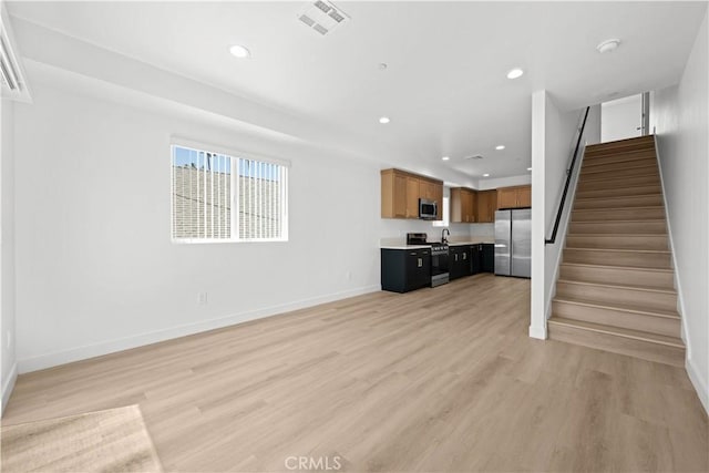 unfurnished living room featuring recessed lighting, light wood-style floors, stairs, and visible vents