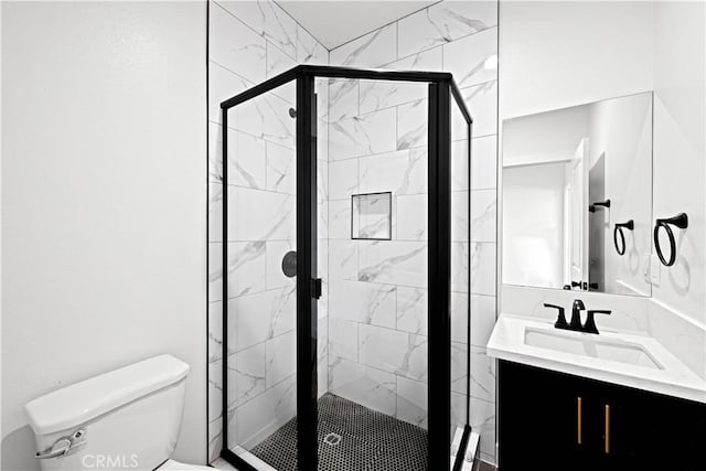 full bath with toilet, vanity, and a shower stall