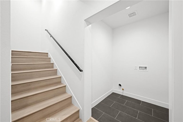 washroom with laundry area, baseboards, visible vents, dark tile patterned flooring, and hookup for a washing machine