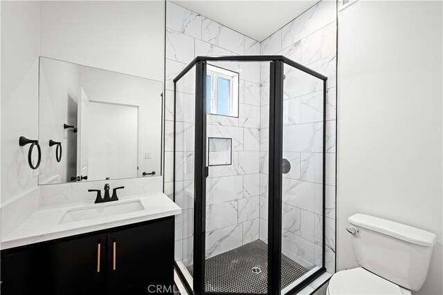 full bath featuring a stall shower, toilet, and vanity