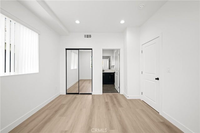 unfurnished bedroom with baseboards, visible vents, recessed lighting, and light wood-type flooring