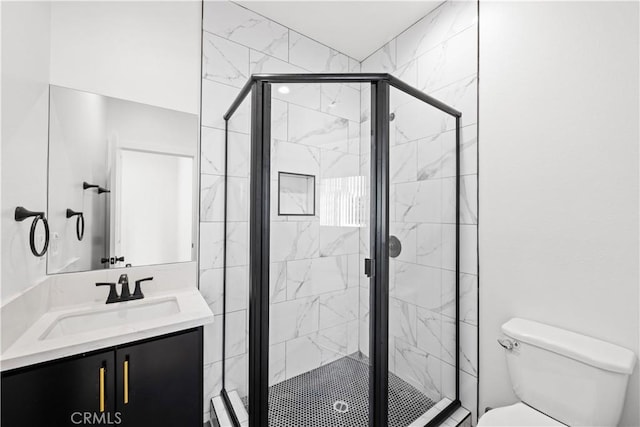 full bath with vanity, toilet, and a shower stall