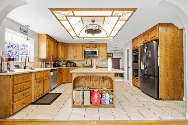 kitchen with light tile patterned floors, a sink, appliances with stainless steel finishes, and decorative backsplash