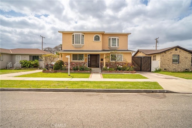traditional-style house featuring concrete driveway, a front yard, and stucco siding