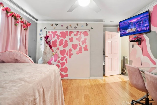 bedroom with wood finished floors, ceiling fan, and crown molding
