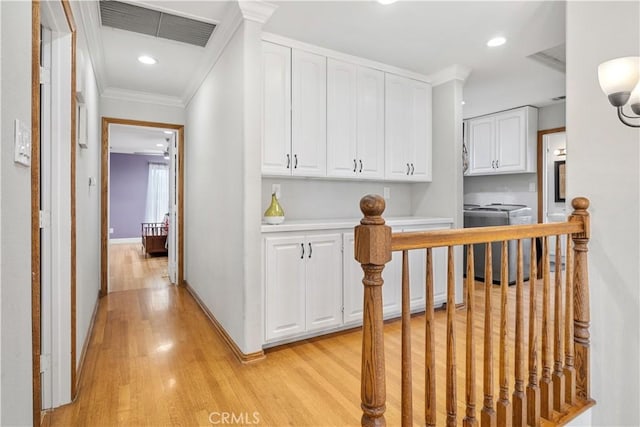 hall featuring recessed lighting, light wood-type flooring, crown molding, visible vents, and baseboards
