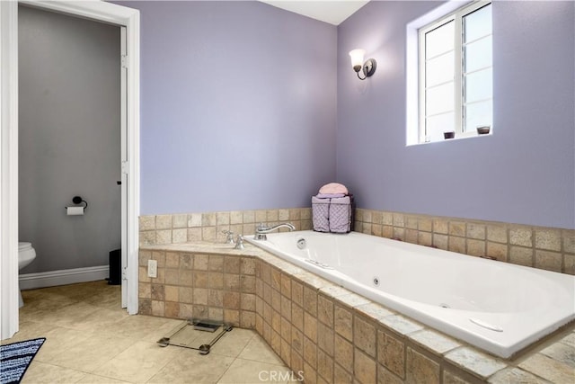 full bathroom featuring tile patterned floors, baseboards, a tub with jets, and toilet