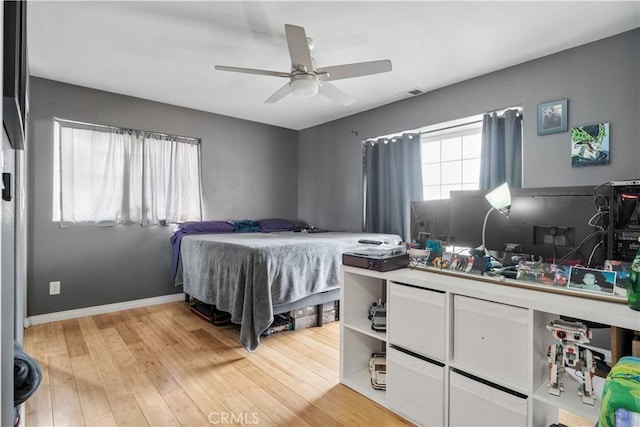 bedroom featuring visible vents, ceiling fan, light wood-style flooring, and baseboards
