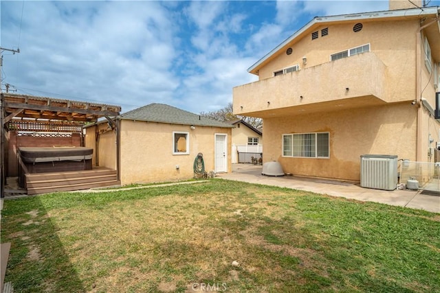 back of house with a patio area, fence, stucco siding, and a hot tub