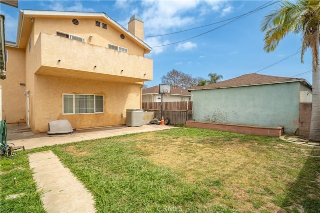 rear view of property featuring a lawn, fence, stucco siding, and a patio area