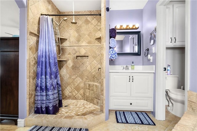 bathroom with tile patterned floors, a shower stall, toilet, and vanity