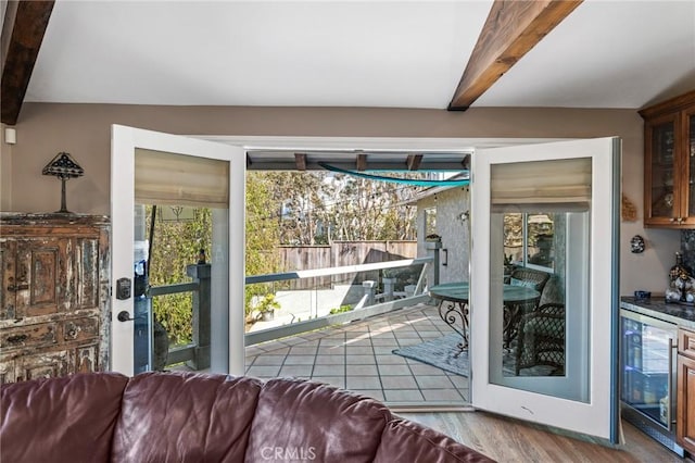 entryway featuring wine cooler, beam ceiling, and a healthy amount of sunlight