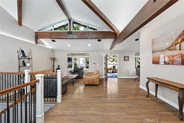 living room with baseboards, beam ceiling, high vaulted ceiling, and wood finished floors
