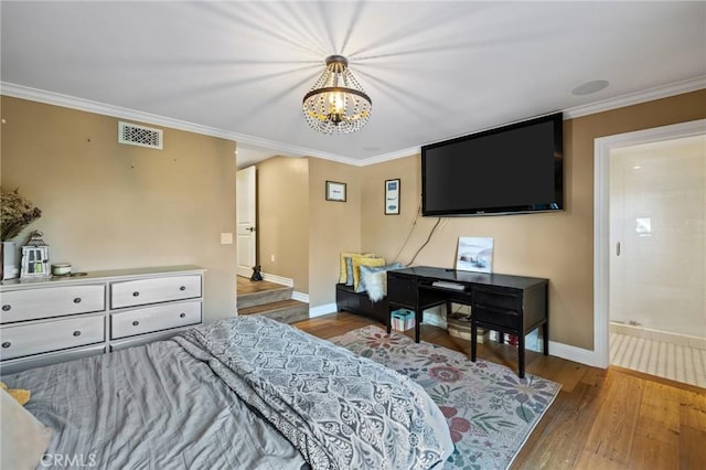 bedroom with visible vents, baseboards, wood finished floors, and an inviting chandelier