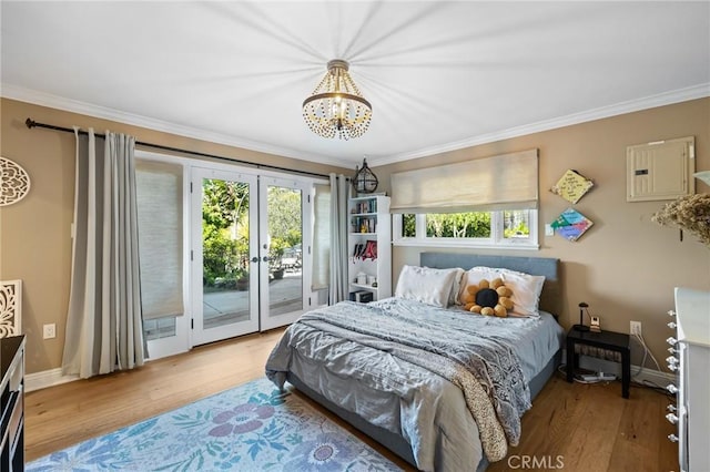 bedroom with french doors, access to exterior, crown molding, wood finished floors, and a chandelier