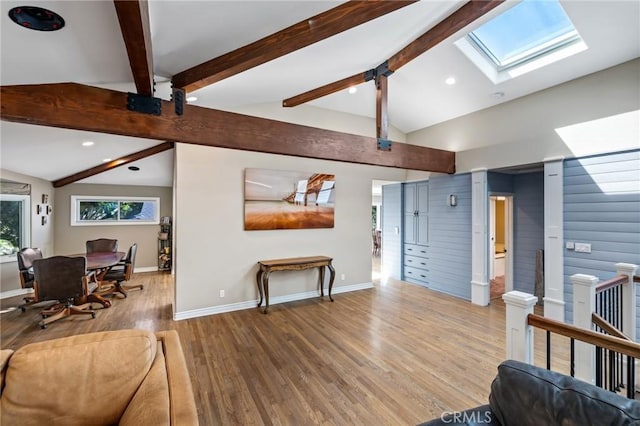 living room featuring recessed lighting, baseboards, wood finished floors, and lofted ceiling with skylight